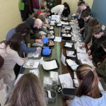 Scouts and parents in Cleveland diligently work to prepare and pack Pocket First Aid Kits