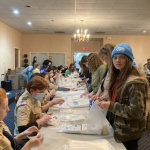 In Whippany, NJ Plast scouts together with U.S. scouts share the task of stuffing bags before vacuum sealing Pocket First Aid Kits.