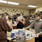 Scouts in Passaic, NJ examine supplies and carefully check the best way to prepare bags for sealing Pocket First Aid Kits