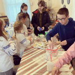 Scouts in Boston, some in Ukrainian embroidered blouses, gather to prepare Pocket First Aid Kits